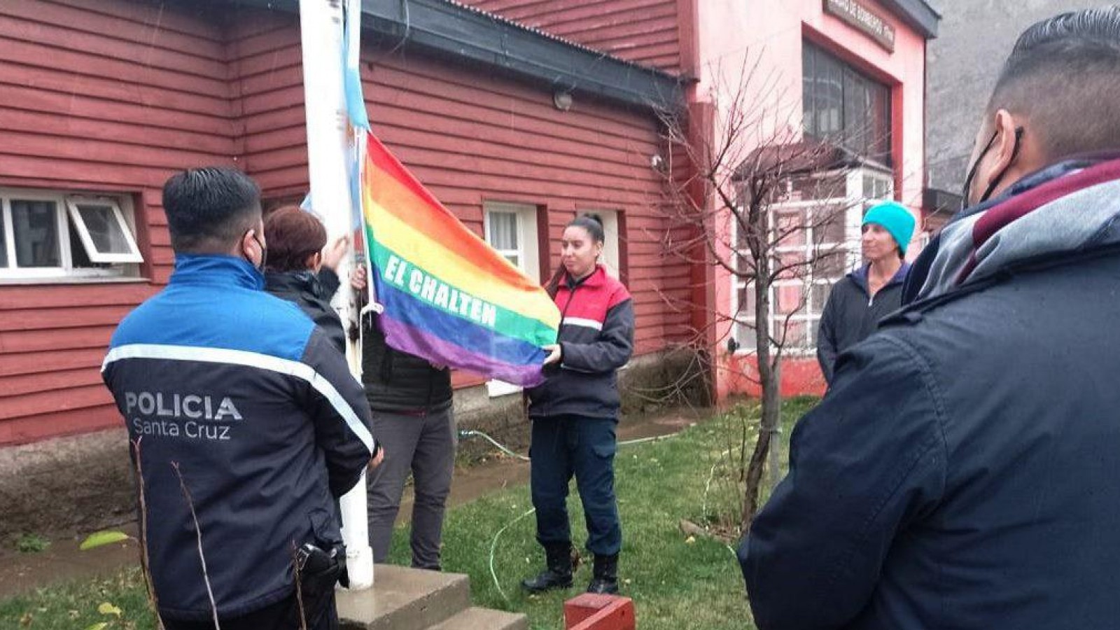 Oficiales de la policía provincial bajando la bandera de la comunidad LGTB+